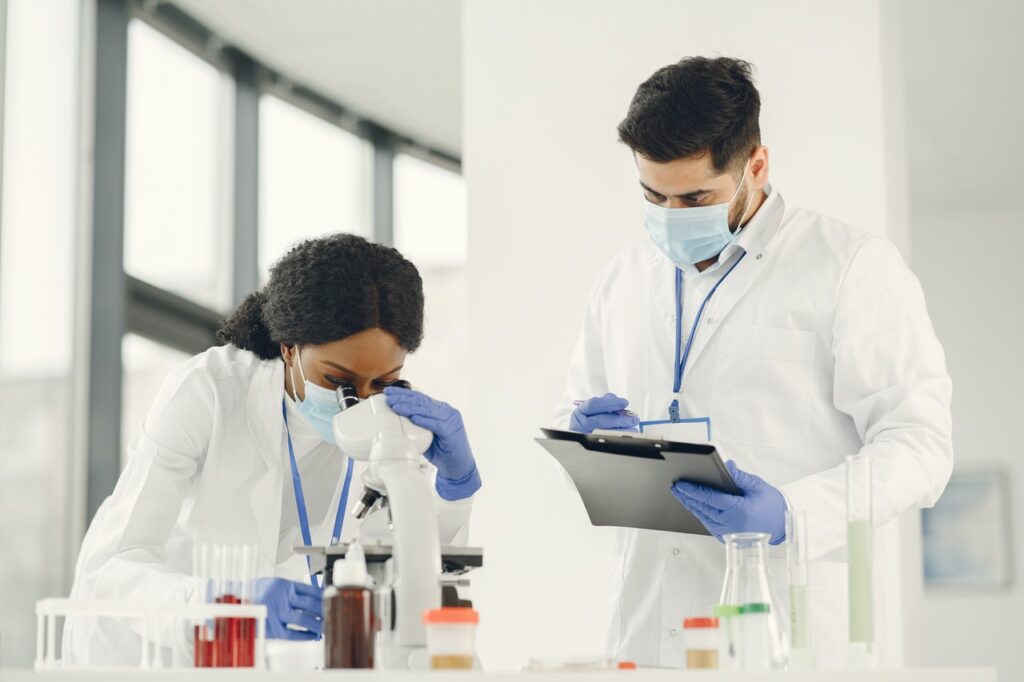 Man and woman wearing white lab coat doing laboratory analysis
