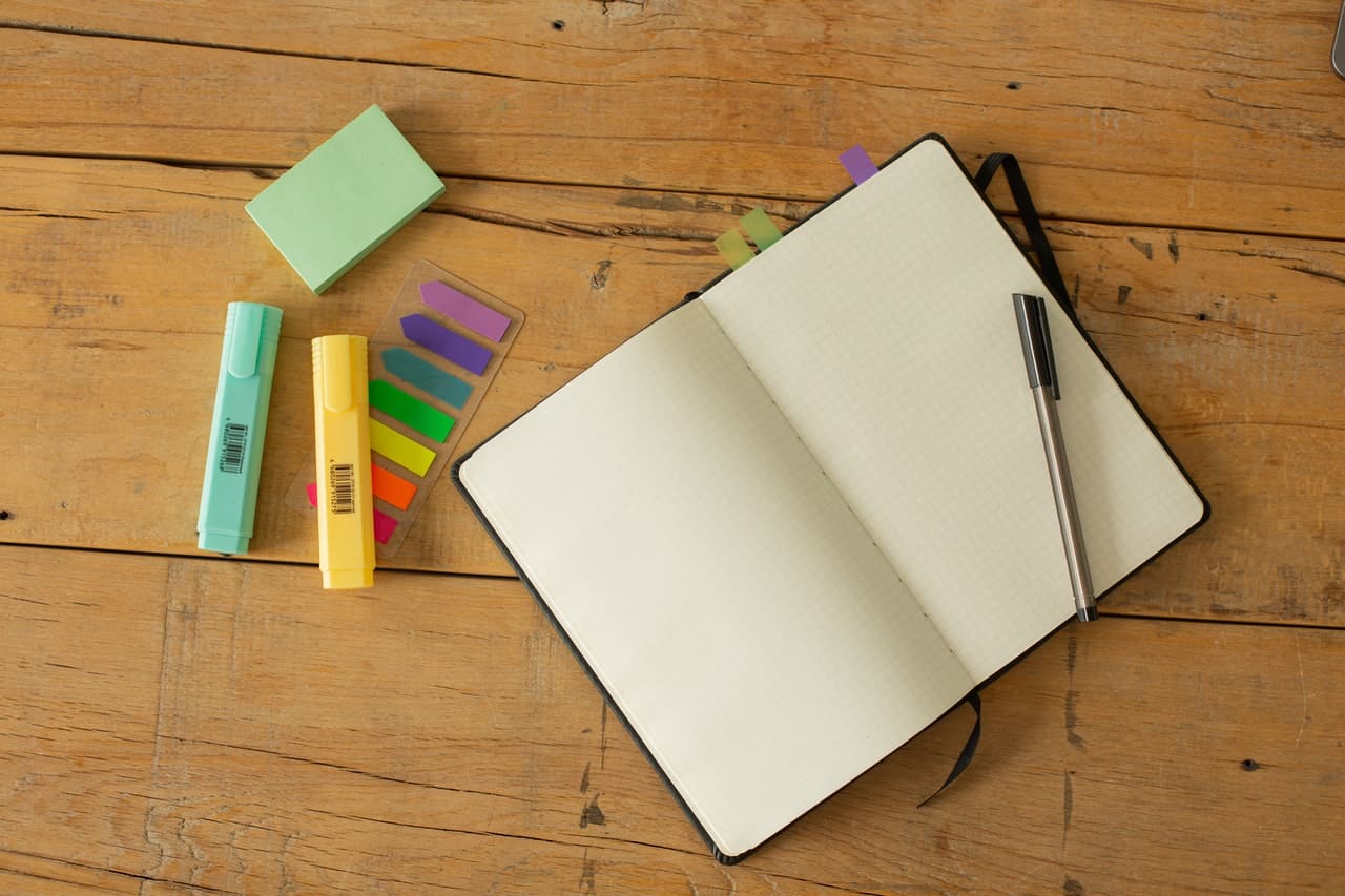 Opened notebook with blank pages and highlighters - Featured image for PEEL Paragraph