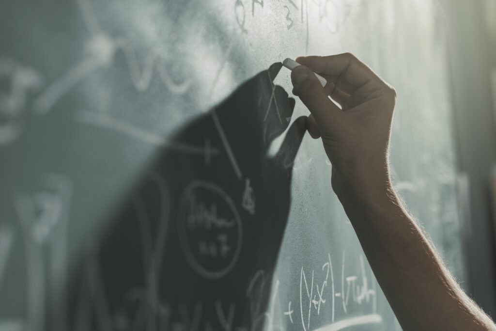 Writing on a chalkboard - Physics Research Investigation Featured Image
