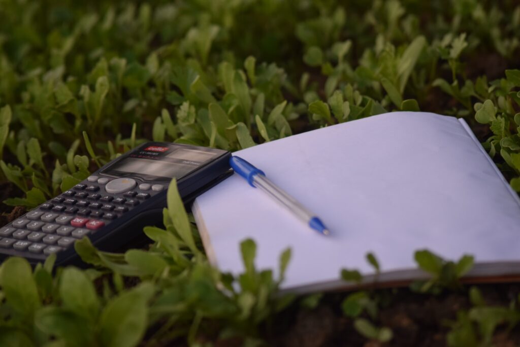Calculator and notebook on green foliage - Maths Methods External Assessment