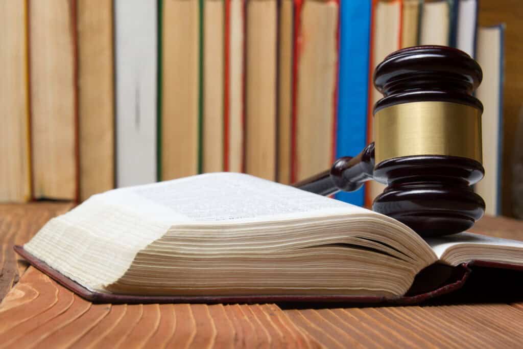 Law book with wooden judges gavel on table in a courtroom or law enforcement office - VCE Legal Studies Past Exams