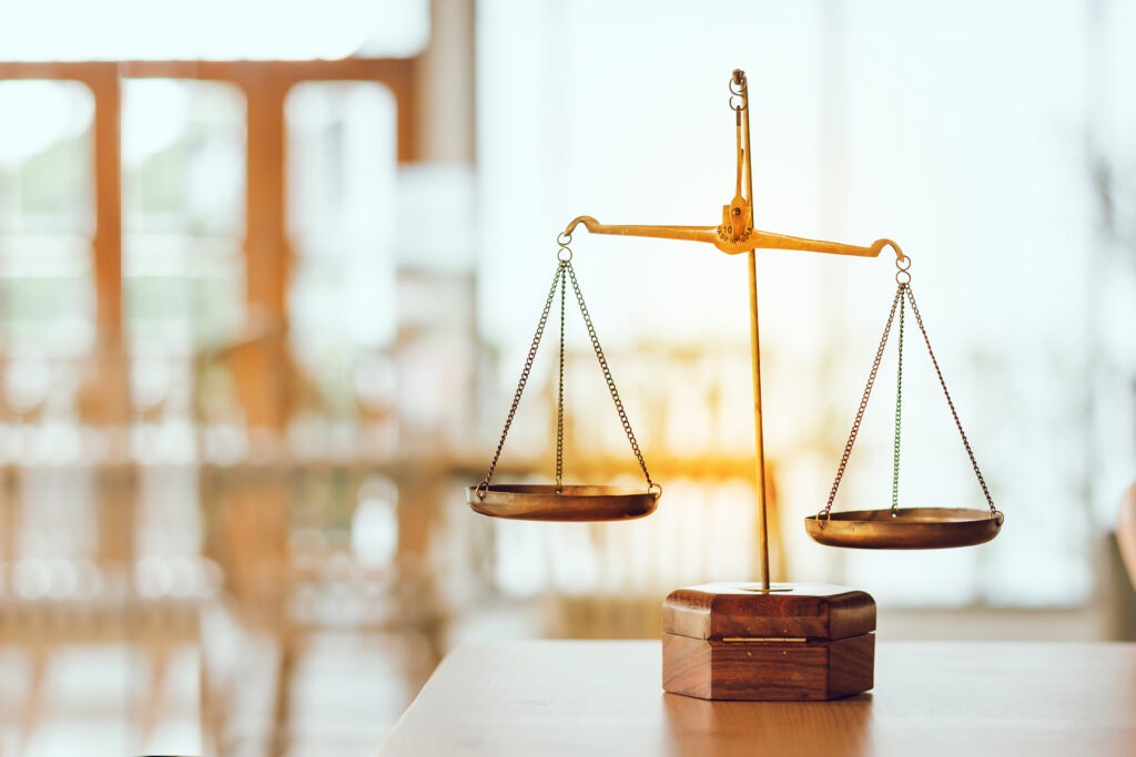 Symbol of law and scales of justice on wooden table in Legal office