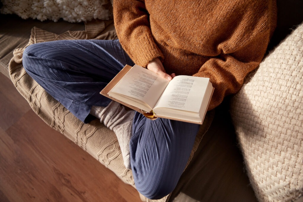 Person in warm sweater reading book at home - Emily Dickinson Quotes